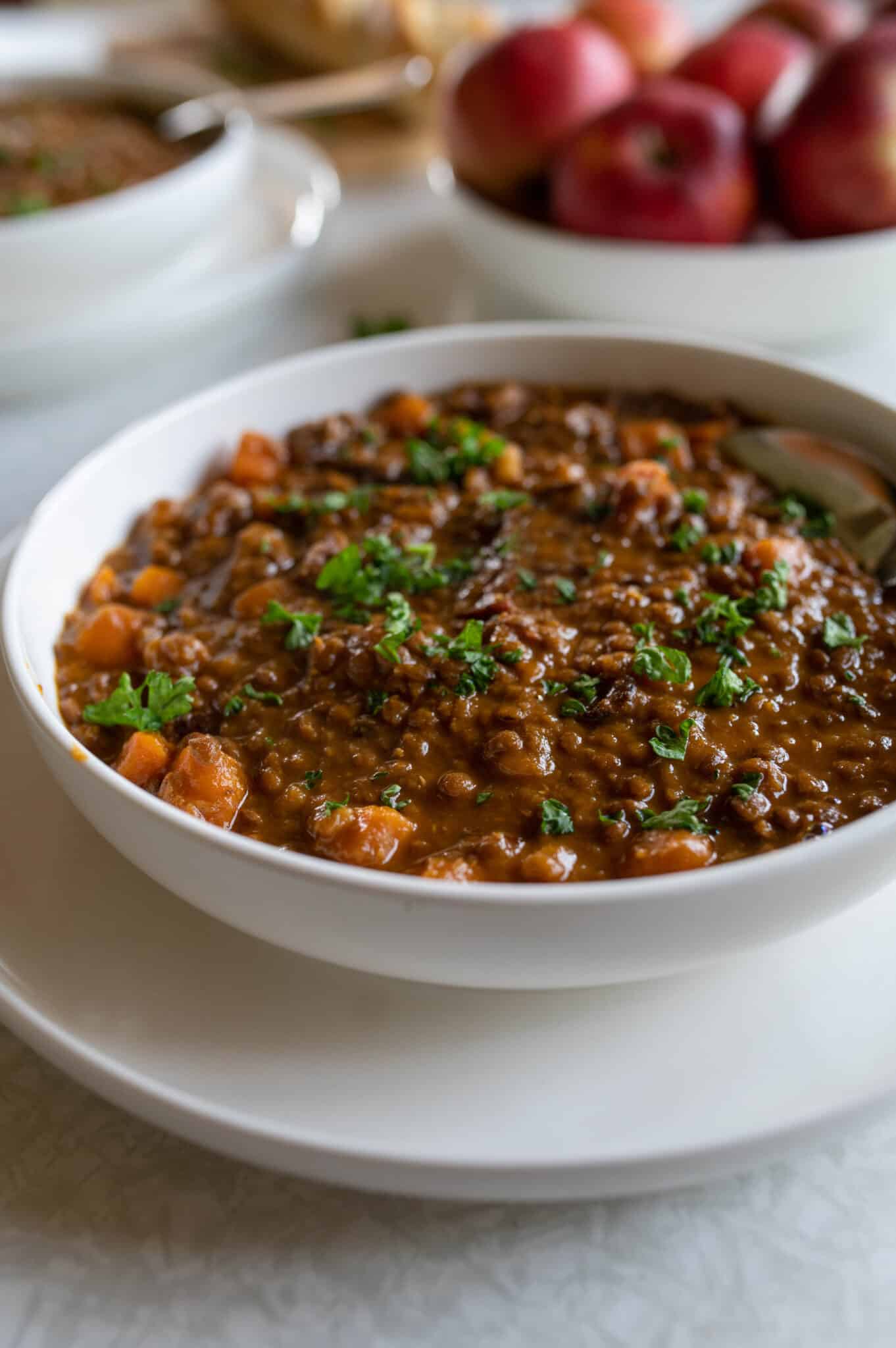 Bowl of thick beef lentil soup with carrots, tender beef, lentils, and parsley.