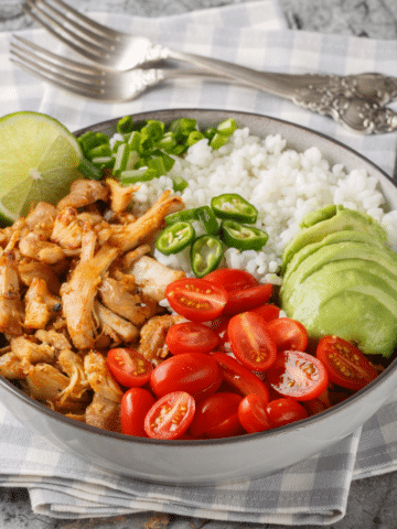 Leftover pork carnitas bowl with rice avocado tomatoes jalapeños and lime