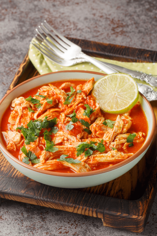 Slow cooker salsa chicken served with fresh lime and herbs